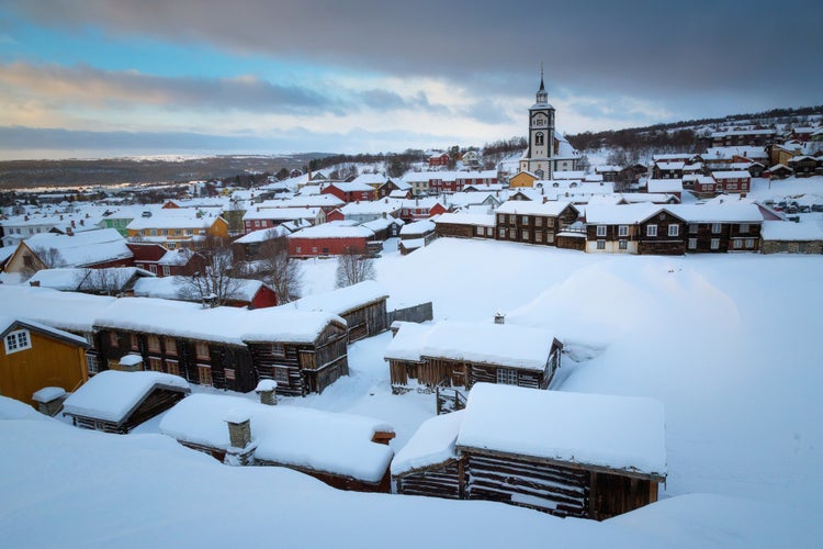 photo of view of Wintertime in Roros, mining old town. Original wooden architecture covered by snow. Cold winter scenery.