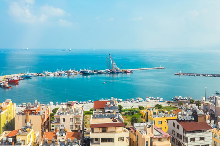 Industrial port or harbor with container or cargo ships and cranes in iskenderun seaport at Hatay city of Turkey. Transportation and logistic at Mediterranean sea.