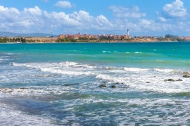 Photo of Saint Anastasia Island in Burgas bay, Black Sea, Bulgaria. Lighthouse tower and old wooden buildings on rocky coast.