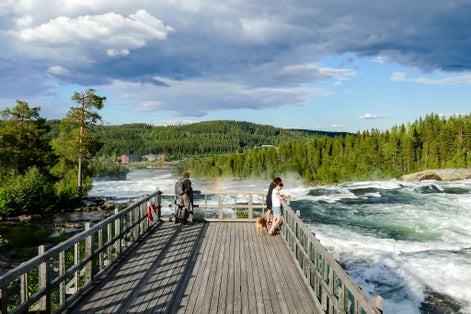 photo of tourists watching the Ristafallet waterfall in Hålland in Sweden.