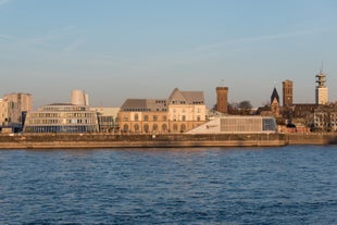 Cologne Aerial view with trains move on a bridge over the Rhine River on which cargo barges and passenger ships ply. Majestic Cologne Cathedral in the background.