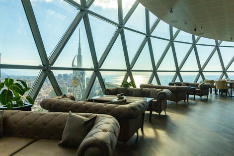 Photo of the interior of the restaurant on the top of the famous Alphabet tower at historical center. The window offers a beautiful view of the black sea and the building old city, Batumi, Georgia.