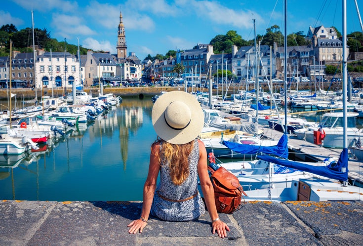 Rear view of woman with hat looking at French village- travel, vacation, tourism concept(Brittany in France, Saint Brieuc)