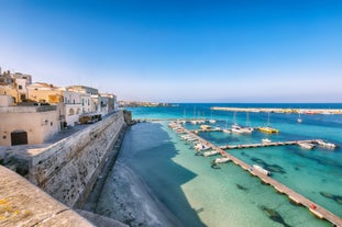 Photo of aerial view of Otranto town in Puglia with crystal turquoise waters, Italy.