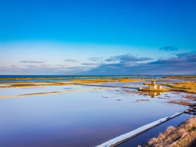 Photo of Saint Anastasia Island in Burgas bay, Black Sea, Bulgaria. Lighthouse tower and old wooden buildings on rocky coast.