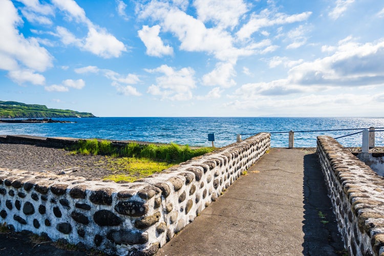 photo of view of Coastal promenade along Almoxarife beach with azure ocean water, Faial island, Azores, Portugal.