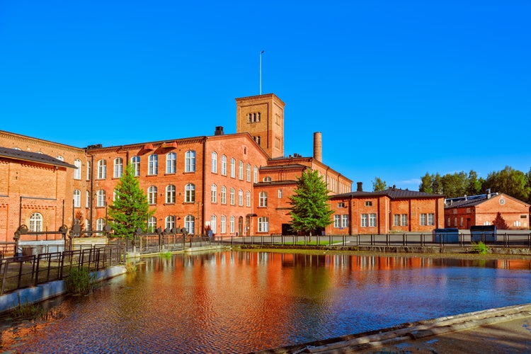 Old cotton spinning mill buildings of red brick at later afternoon. Forssa, Finland