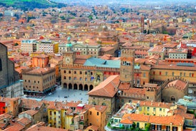 Photo of Italy Piazza Maggiore in Bologna old town tower of town hall with big clock and blue sky on background, antique buildings terracotta galleries.