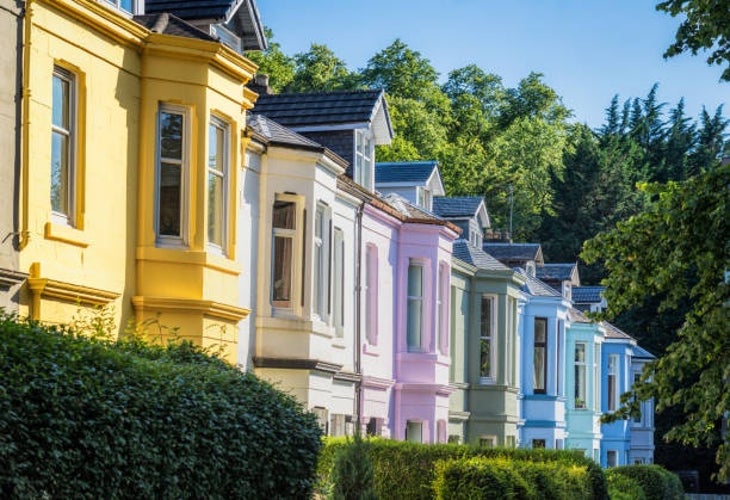 A row of Victorian townhouses in Southside Glasgow, Scotland, each painted in a range of bright colors.jpg