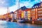 Photo of scenic summer sunset view of Nyhavn pier with color buildings, ships, yachts and other boats in the Old Town of Copenhagen, Denmark.