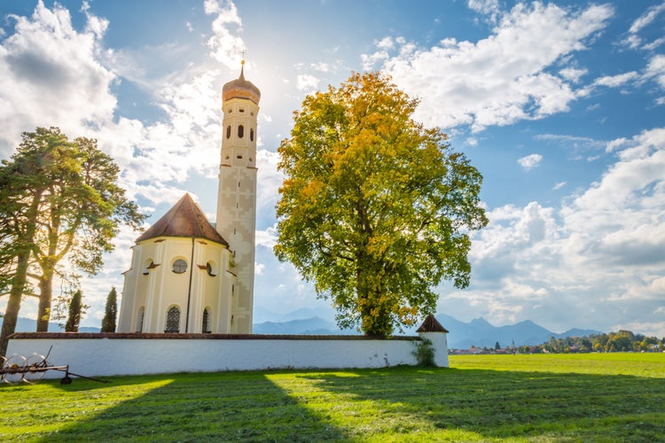 Photo of Panoramic scenery of St Coloman's Church, Schwangau with wonderful cloud and ray of morning sun light shining over alps snow mountain, baroque church of Coloman, Irish pilgrim, Holy land.