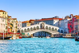 Famous buildings, gondolas and monuments by the Rialto Bridge of Venice on the Grand Canal, Italy.