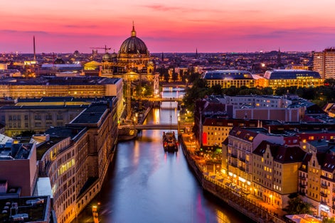 Panoromic aerial view of Berlin skyline with famous TV tower and Spree river in beautiful post sunset twilight during blue hour at dusk with dramatic colorful clouds , central Berlin Mitte, Germany