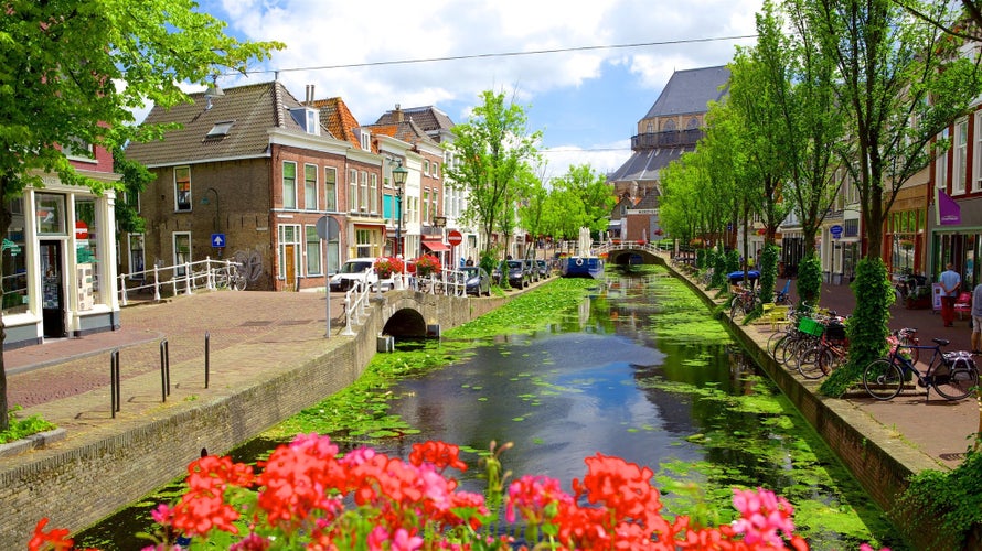 Picturesque Delft cityscape view with Eastern Gate Oostport and canal with cars and bicycles parked along. Delft, Netherlands's