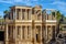 Photo of Stage of the Roman Theater of Mérida with Greek and Roman marble columns, lighting spotlights on scaffolding for the Mérida international theater festival. Sunny day before the evening performance.