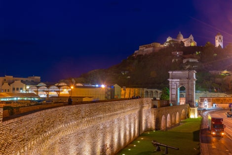 Night view of cathedral of San Ciriaco behind Arco di Traiano in Ancona, Italy.