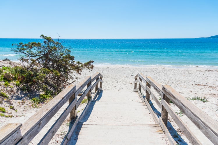 Photo of wooden bordwalk in Maria Pia beach. Alghero, Sardinia, Italy.