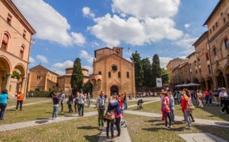 Photo of Italy Piazza Maggiore in Bologna old town tower of town hall with big clock and blue sky on background, antique buildings terracotta galleries.