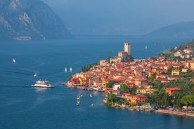 Photo of aerial view of superb Malcesine Mediterranean cityscape with colorful buildings and boats, yachts in the bay, lake Garda, Italy.