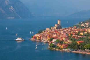 Photo of aerial view of superb Malcesine Mediterranean cityscape with colorful buildings and boats, yachts in the bay, lake Garda, Italy.