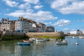 Photo of Vannes, beautiful city in Brittany, boats in the harbor, with typical houses and the cathedral in background, France.