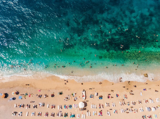 Drone footage of people sunbathing on Kaputaş beach near Kalkan - Kaş, Antalya, Turkey.