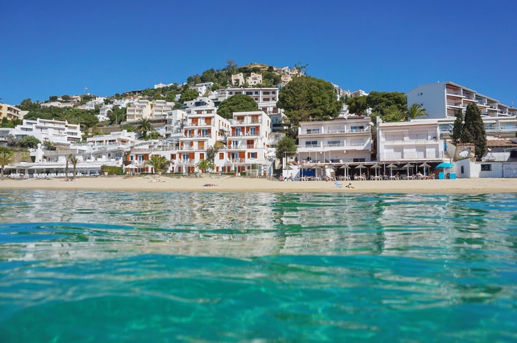 Photo of Spain Costa brava beautiful beach with buildings waterfront, Mediterranean, seen from sea surface, Roses.