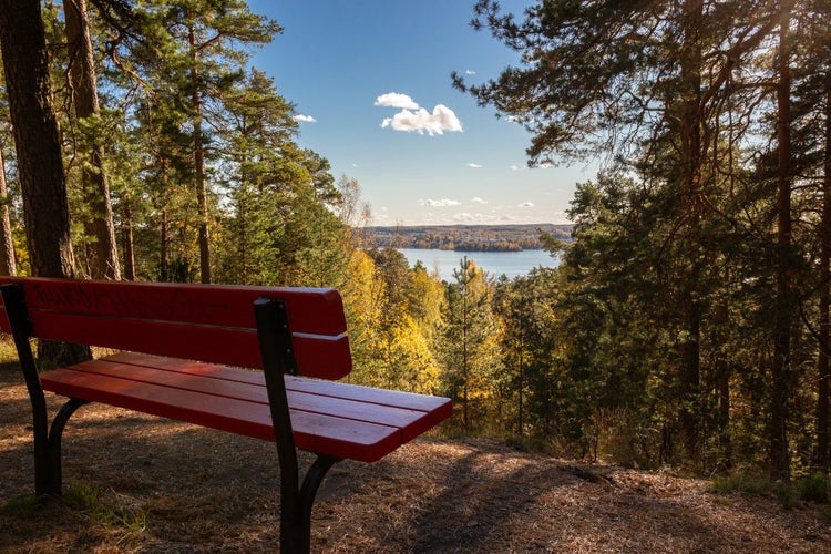 Photo of red bench and lake Pyhäjärvi in Tampere, Finland.