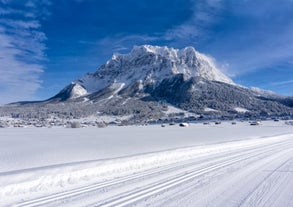 Photo of a view of the Alps from the Ehrwald, a town on the border of Germany and Austria with picturesque meadows surrounded by towering mountain ranges, including the Zugspitze.