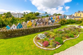 Photo of Colorful row houses with towering cathedral in background in the port town of Cobh, County Cork, Ireland.