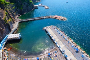 photo of aerial panorama of high cliffs, Tyrrhenian Sea Bay with pure azure water, floating boats and ships, pebble beaches, rocky surroundings of Meta in Sant'Agnello and Sorrento cities near Naples region in Italy.