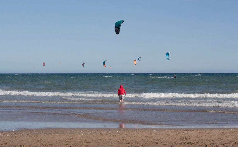 activity on the beach Castelldefels. Fishing and nautical sports. Location of Barcelona, ​​Catalonia, Spain. Holidays. Leisure. Kitesurfers on a flat azure water of Mediterranean Sea