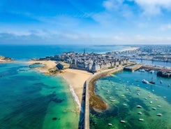 Photo of Vannes, beautiful city in Brittany, boats in the harbor, with typical houses and the cathedral in background, France.