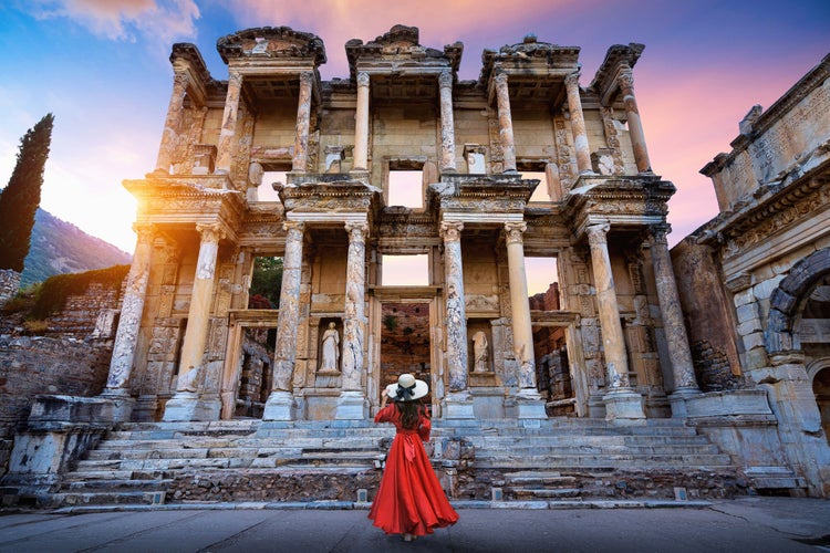 Photo of woman standing in Celsus Library at Ephesus ancient city in Izmir, Turkey.