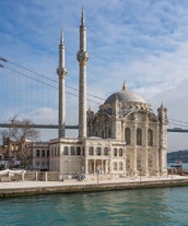 Touristic sightseeing ships in Golden Horn bay of Istanbul and mosque with Sultanahmet district against blue sky and clouds. Istanbul, Turkey during sunny summer day.