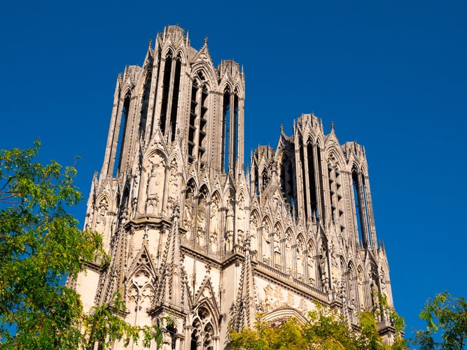 photo of view of View of magnificent gothic building of Notre-Dame de Reims, Roman Catholic cathedral in Place du Cardinal Lucon on sunny summer day, France