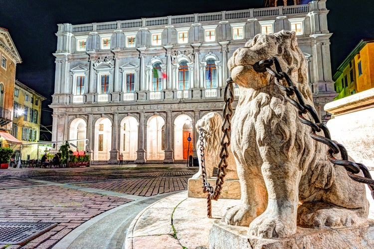 Piazza Vecchia, Citta Alta, Bergamo, Italy. Night view on the square with the beautiful fountain in the center of the square illuminated by night lights.