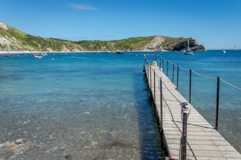 Photo of a lovely sunny morning and jetty in Lulworth Cove on Dorset's Jurassic Coast in south-west England.