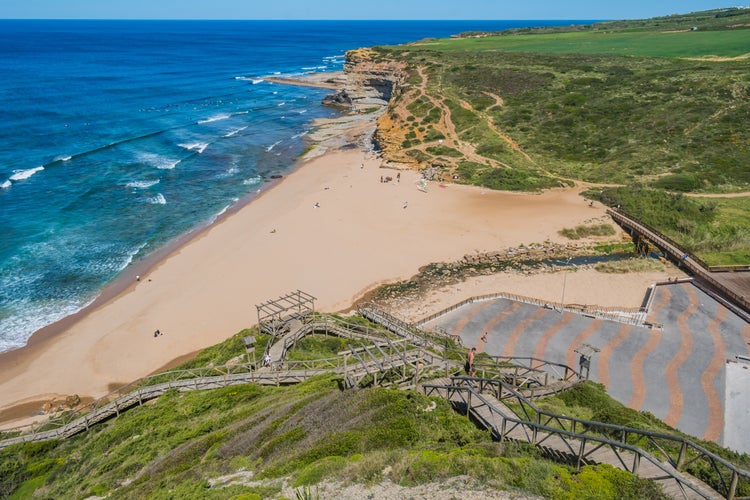 Photo of Walkway on a hill in aerial view with sand and bridge over river at Ribeira D'Ilhas beach, Ericeira - Mafra PORTUGAL.