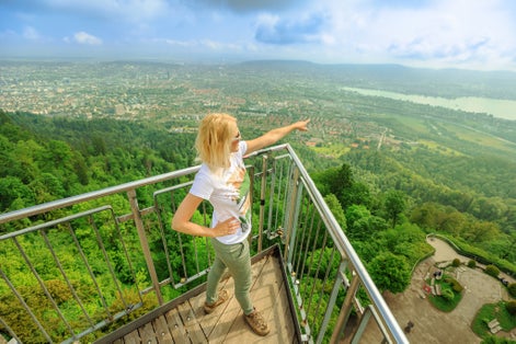 photo of woman by Zurich cityscape on a Swiss lookout tower on Uetliberg mountain in Swiss plateau of Switzerland.
