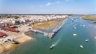 Photo of aerial cityscape of beautiful Tavira with roman bridge over Gilao river in the evening, Algarve, Portugal.