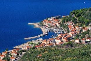 Photo of panorama and landscape of Makarska resort and its harbour with boats and blue sea water, Croatia.