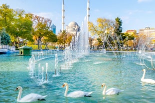 Touristic sightseeing ships in Golden Horn bay of Istanbul and mosque with Sultanahmet district against blue sky and clouds. Istanbul, Turkey during sunny summer day.