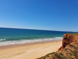 photo of an aerial view of wide sandy beach in touristic resorts of Quarteira and Vilamoura, Algarve, Portugal.