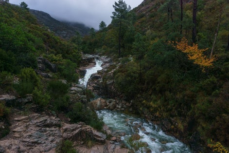 Small waterfall Cascata da Portela do Homem and mountain river with much water during autumn, Peneda-Geres National Park, Vilar da Veiga, Portugal