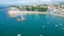 Photo of aerial view of a water fountain on the Paço de Arcos beach and the boats on bay, at background the beach.