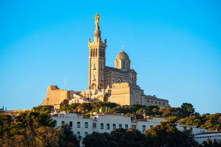 Notre-Dame de la Garde basilica in Marseille, France, perched on a hilltop and lit by golden afternoon sunlight..jpg