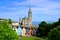 Photo of Colorful row houses with towering cathedral in background in the port town of Cobh, County Cork, Ireland.