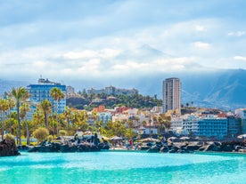 Photo of aerial view with Puerto de la Cruz, in background Teide volcano, Tenerife island, Spain.